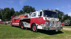 a red and white fire truck parked in the grass