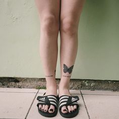 a woman's legs with butterfly tattoos on them