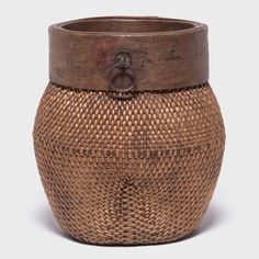 a brown vase with a wooden lid on it's sides and a metal ring at the top