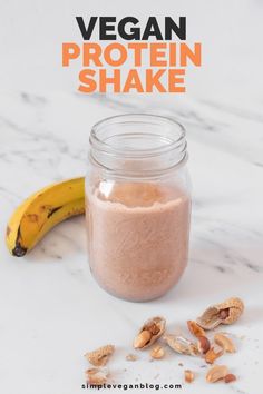 a glass jar filled with protein shake next to a banana