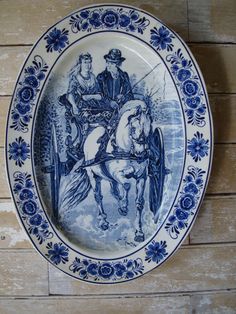 a blue and white plate with an image of a man on a horse