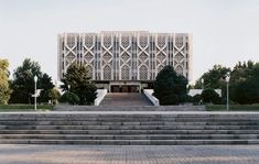 a building with steps leading up to it and trees in the backgrouds