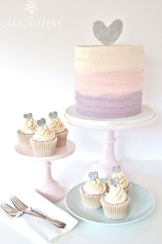 there are two cupcakes on the plate and one is pink, purple, and white