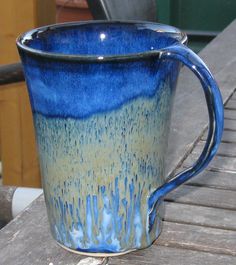 a blue and yellow mug sitting on top of a wooden table