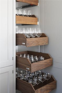 wine glasses are stored in wooden trays on the wall