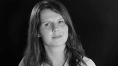 a black and white photo of a woman with long hair wearing a button up shirt