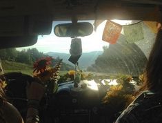 the sun shines through the windshield of a car as it drives down a country road