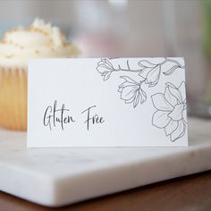 Black line drawn magnolia flower tent fold style buffet food label card. Shown on a white marble board in front of a cupcake Buffet Party Food, Place Name Cards, Place Setting Cards, Buffet Party, Food Label, Wedding Place Settings, Party Food And Drinks, Party Places