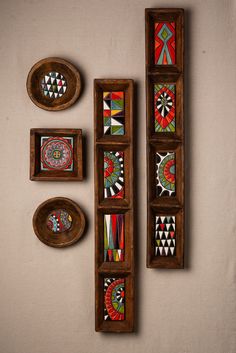 three wooden trays with colorful designs on them and two bowls next to each other