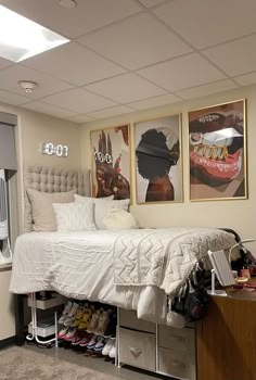 a bed sitting in a bedroom next to two pictures on the side of a wall