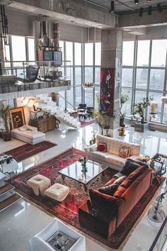 a living room filled with lots of furniture and large windows overlooking the cityscape