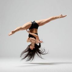 a woman is doing a handstand in the air with her legs spread out