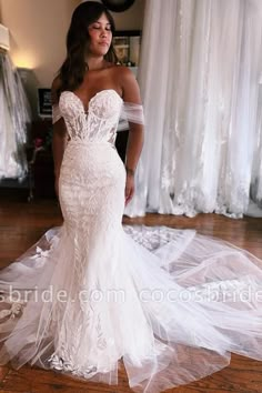 a woman in a wedding dress standing on the floor