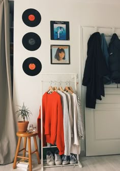 a room with clothes and records on the wall