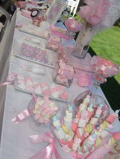 a table topped with lots of pink and white desserts on top of it's sides