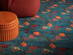 an orange stool sitting on top of a blue carpet next to a red chair and ottoman