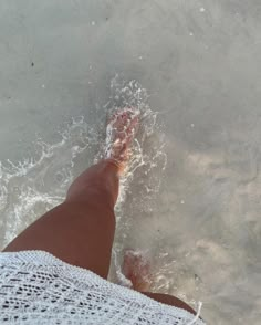 a person's feet in the water at the beach