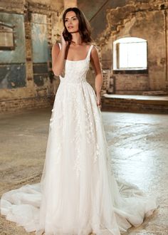 a woman in a wedding dress posing for the camera with her hand on her hip