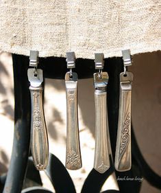 three silver spoons hanging from the side of a chair