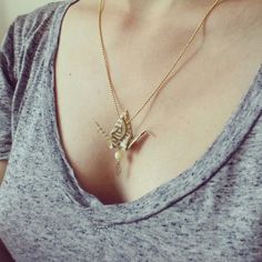 a woman wearing a necklace with a bird on it