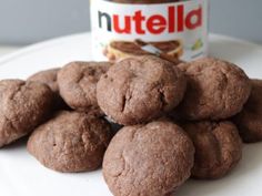 chocolate cookies and nutella are on a plate with a jar of nutella in the background