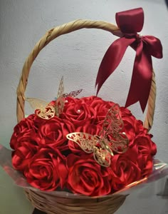 a basket filled with red roses and butterflies