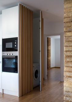 an empty kitchen with white cabinets and wood flooring is shown in this image from the doorway to the living room