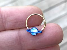 a person holding a ring with an object in it's middle, on their finger