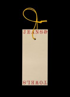 a white bag with a yellow string hanging from it's side on a black background