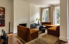 a living room filled with furniture and a flat screen tv on top of a hard wood floor