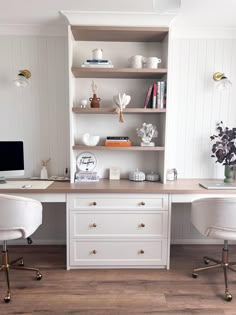 a desk with two chairs and a computer on top of it in front of a book shelf