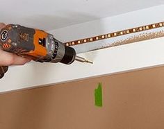 a person using a drill to fix a hole in the ceiling with a screwdriver