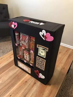 a black box with pink hearts on it and some candy in the front is made to look like a vending machine