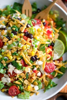 a salad with corn, tomatoes, black olives and cheese