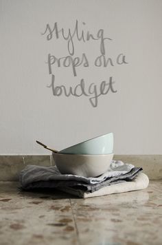 a white bowl sitting on top of a counter next to a wall with writing on it