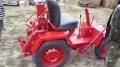 a man standing next to a red tractor