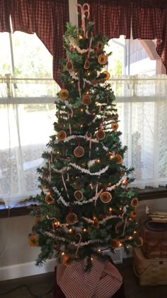 a decorated christmas tree in front of a window