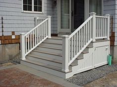 a house with white railing and steps leading up to the front door