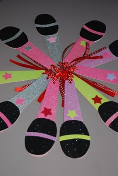 a group of black and pink spoons sitting on top of a white table next to each other