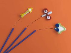 three toothbrushes, one blue and one yellow are on an orange surface with the other white