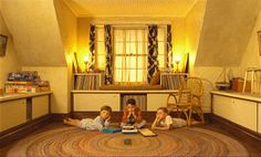 three children laying on the floor reading books