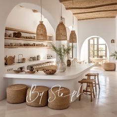 an open kitchen and dining area with white counter tops, wicker stools and hanging lights