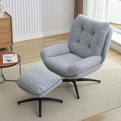 a living room with a chair and ottoman on the floor next to a coffee table