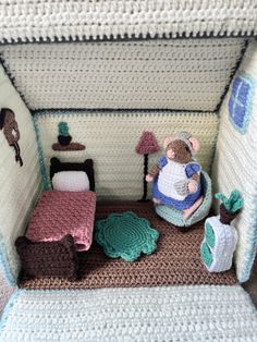 there is a crocheted dollhouse with a bed and chair in it's corner