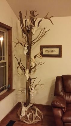 a living room with a couch and a tree in the corner that has white flowers on it