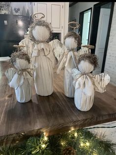 some white angel figurines sitting on top of a table next to christmas decorations