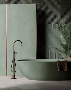 a green bathtub with a gold faucet next to it and a plant in the corner