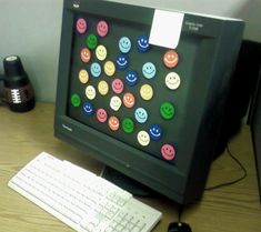 a computer monitor sitting on top of a wooden desk next to a keyboard and mouse