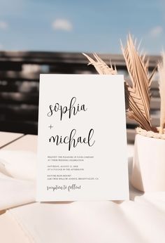 a table with a sign and some plants on top of it that says, sophia + michael