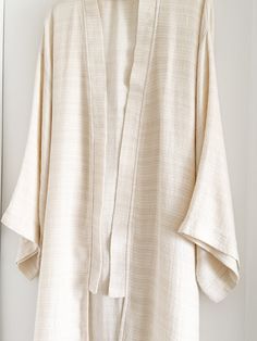 Elevate your lounge wear style with the Ivory Smooth Textured Turkish Cotton Kimono, woven with a beautifully intricate pattern that feels incredibly soft against the skin. Crafted from 100% Turkish Cotton, it ensures both comfort and style for your moments of relaxation at home. Available in one size. Color: Ivory. Material: 100% Cotton. Made in Turkey. Unisex one size. Machine wash delicate. Tumble Dry low. Elegant Long Sleeve Relaxed Fit Kimono, Beige Relaxed Fit Kimono For Loungewear, Relaxed Fit Beige Kimono For Loungewear, White Spring Kimono For Relaxation, Elegant Beige Kimono For Loungewear, White Relaxed Fit Kimono For Loungewear, Elegant Cotton Kimono, Cream Long Sleeve Kimono For Loungewear, White Long Sleeve Relaxed Fit Kimono